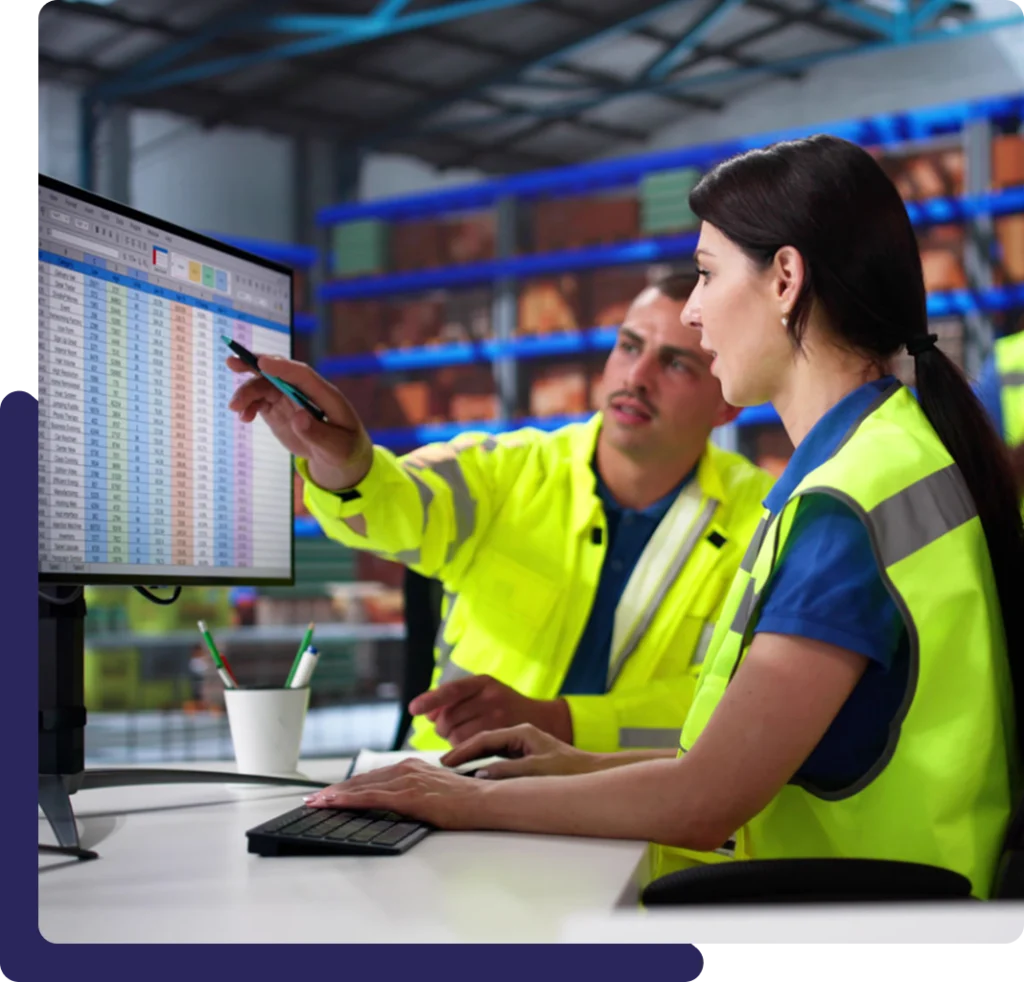 Two workers analyzing data on computer screen.